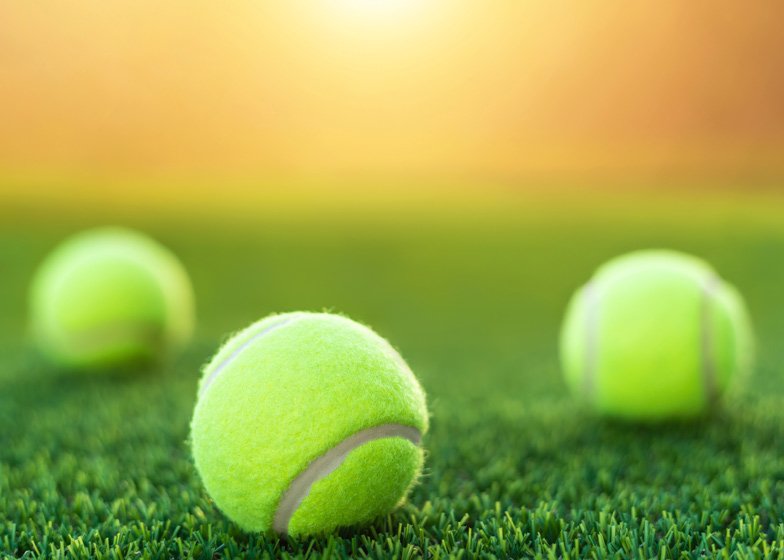 Tennis balls on a green grass tennis court